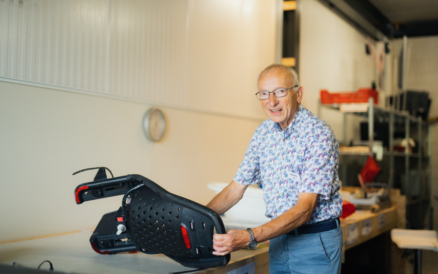Vrijwilliger Roel uit Hardenberg controleert een kinderzitje voor de fiets op herbruikbaarheid.